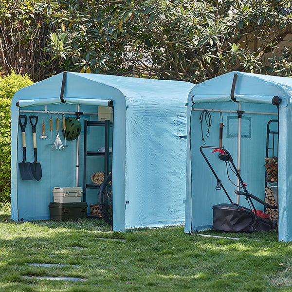 Zwei blaue Gartengerätehäuser im Garten mit Gartengeräten und Werkzeugen