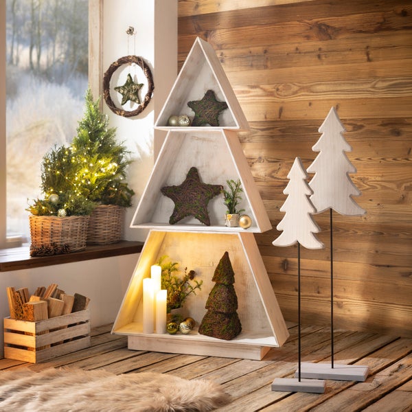 Weihnachtsdekoration im Wohnraum mit dreieckigem Regal in Tannenbaumform, Holzsternen, LED Kerzen und zwei Tannenbaum Aufstellern aus Holz.