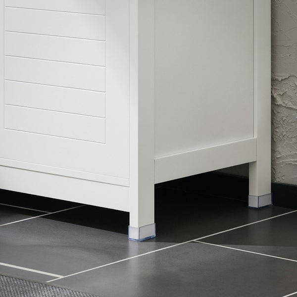 Detailansicht eines weißen Badezimmerschranks mit Bodenschonern an den Füßen.