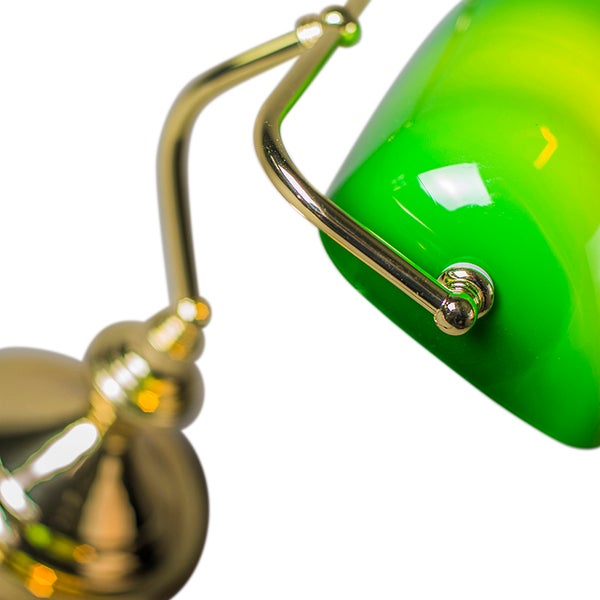 Detailansicht einer Schreibtischlampe mit grünem Lampenschirm und goldenem Gestell.