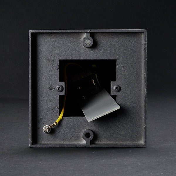 Rückansicht einer quadratischen Außenwandleuchte aus Metall mit Befestigungslöchern und sichtbarem Erdungskabel.