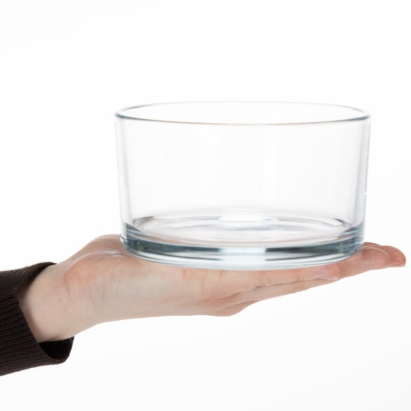 Transparente, zylindrische Glasschale auf einer Hand zur Veranschaulichung der Größe.