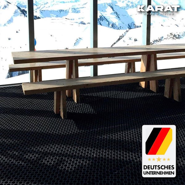 Helle Terrasse mit Ringmatte aus Gummi, Holzmöbeln und Bergblick. KARAT HOME & LIVING Logo. Siegel für ein deutsches Unternehmen.