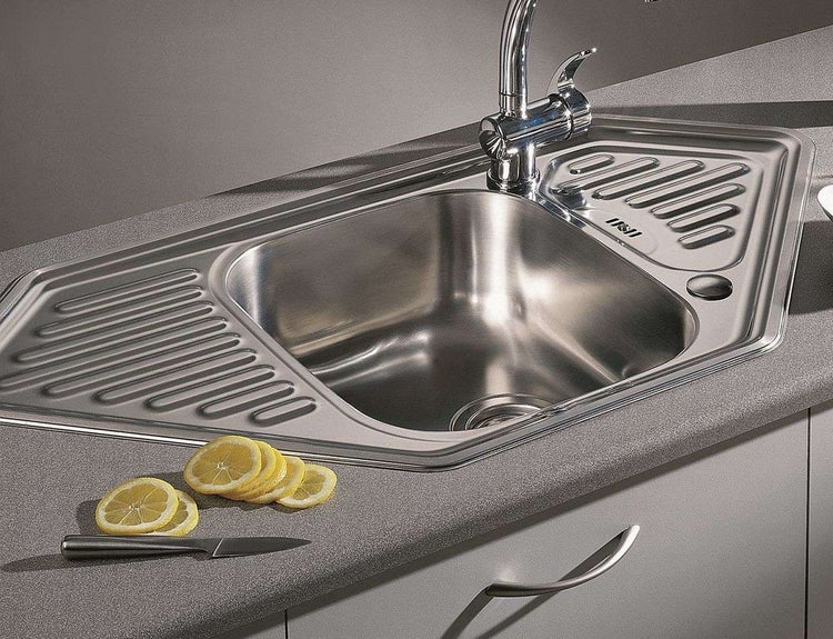 Eckspüle aus Edelstahl mit Abtropffläche, Wasserhahn und Zitrone
