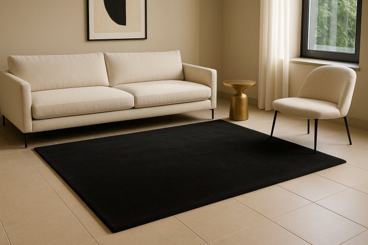 Ein moderner Wohnbereich mit einem rechteckigen, schlichten Teppich auf einem gefliesten Boden vor einem Sofa und einem Sessel.