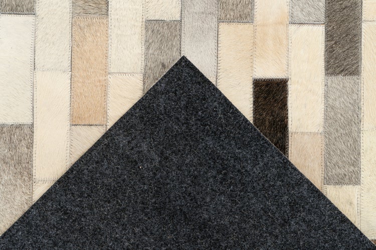 Kuhfell-Teppich im Patchwork-Design aus rechteckigen Stücken mit einer Rückseite aus dunklem Filz.