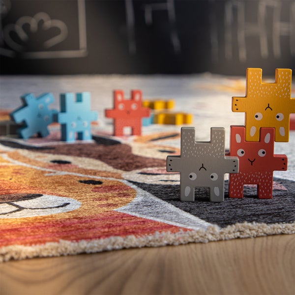 Kinderspielteppich mit Tier-Motiv und bunten Holzspielzeug-Figuren in Hasenform.