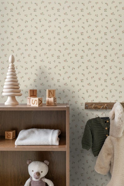 Vliestapete mit kleinem floralem Muster in einem hellen Kinderzimmer mit Holzregal, Holzspielzeug und Kinderkleidung.
