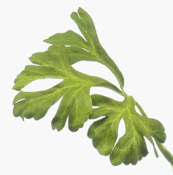 Künstliches grünes Blatt mit mehreren Zacken und sichtbarer Textilstruktur.