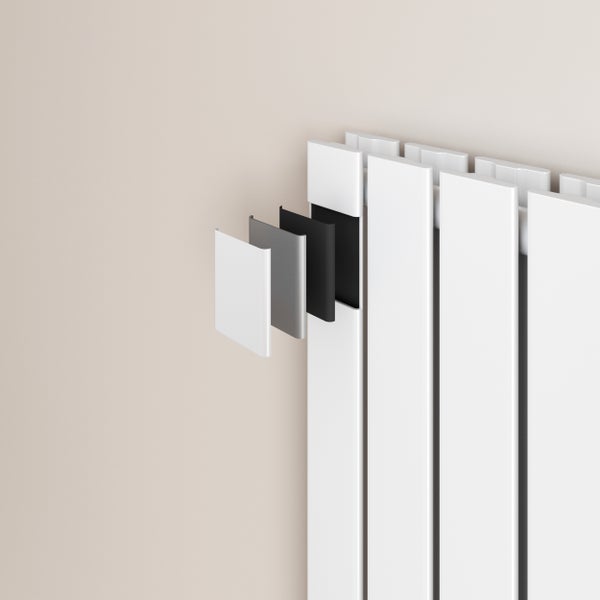 Moderner vertikaler Design-Heizkörper aus weißem Metall an einer hellen Wand in einem hellen Wohnzimmer mit Parkettboden und Vorhängen