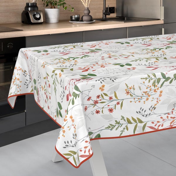 Tischdecke mit floralem Muster aus Blättern und Blüten in einer hellen, modernen Küche.