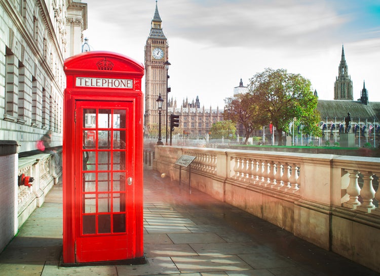 Londoner Stadtansicht mit einer roten Telefonzelle im Vordergrund sowie dem Big Ben und dem Palace of Westminster im Hintergrund.