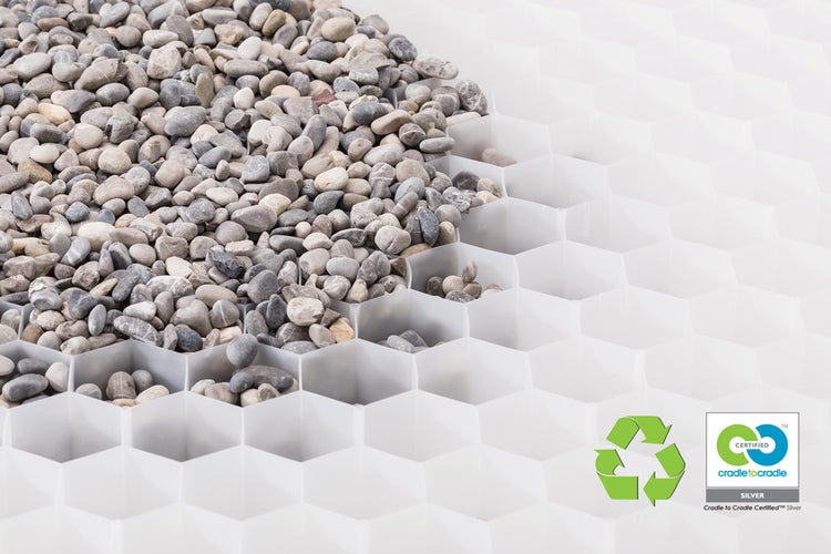 Weiße Kieswabe mit Wabenstruktur, teilweise mit grauen Kieselsteinen gefüllt. Mit Recycling-Symbol und Cradle to Cradle Certified Silver Siegel.
