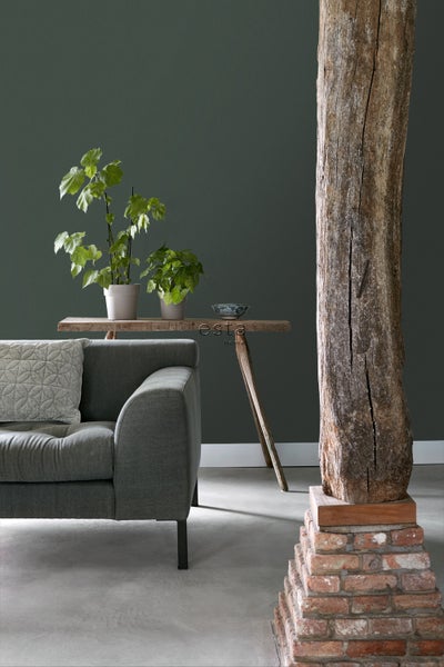 Wohnzimmer mit grauer Couch, Holztisch und dekorativem Holzpfeiler