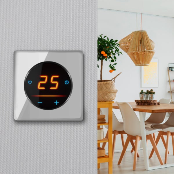 Digitales Raumthermostat mit Touchscreen und Anzeige der Temperatur an einer Wand neben einem eingerichteten Esszimmer.
