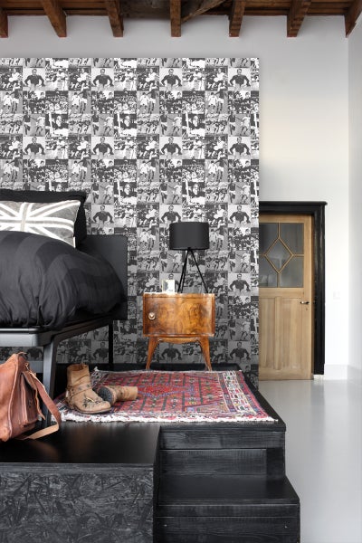 Schlafzimmer mit Bett, Nachttisch und Fototapete mit Sportmotiven