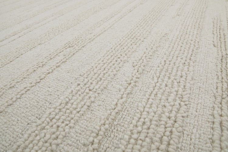 Strukturierter Teppich in Beige mit linearem Muster aus erhabenen Noppen, gewebtes Textil.