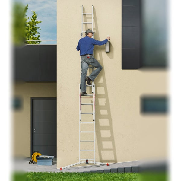 Mann auf einer Mehrzweckleiter, der an einer Hauswand arbeitet.