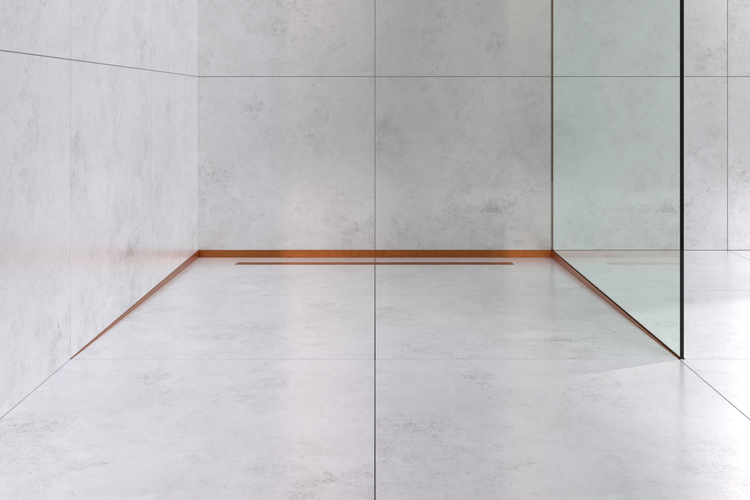 Moderner Duschbereich mit hellgrauen großformatigen Fliesen, gläserner Duschwand und einer linearen Duschrinne mit kupferfarbenem Profil.