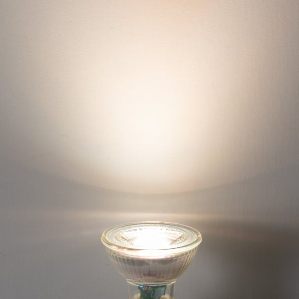 LED-Reflektorlampe mit warmweißem Lichtkegel an einer Wand.