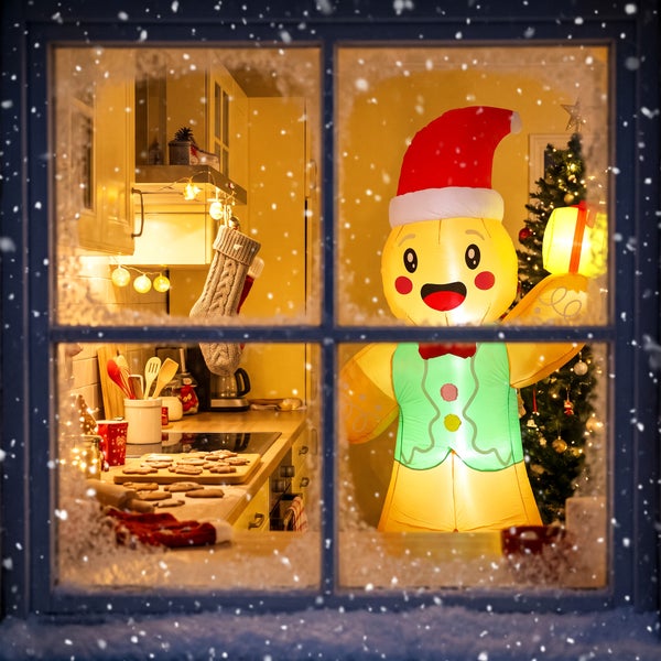 Beleuchtete aufblasbare Lebkuchenmann Figur als Weihnachtsdekoration vor einem weihnachtlich geschmückten Fenster mit Schneefall