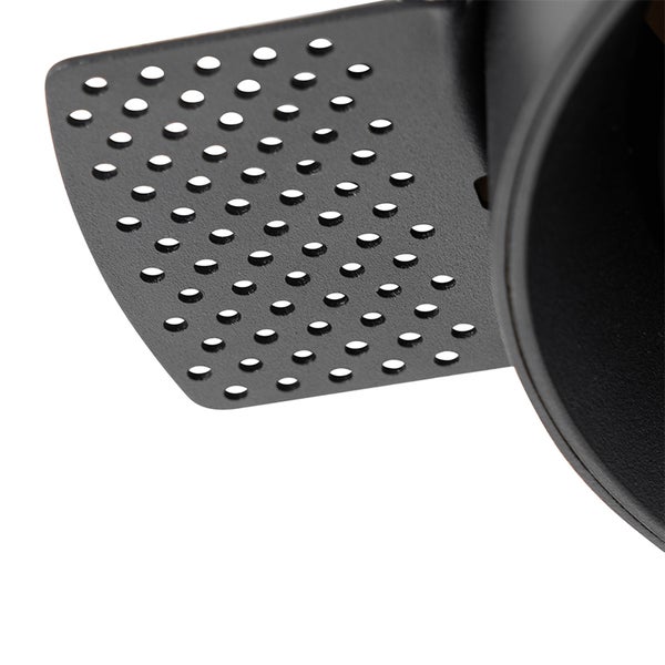 Nahaufnahme einer gelochten Metallplatte aus schwarzem Metall, Teil eines Holzkohlegrills.