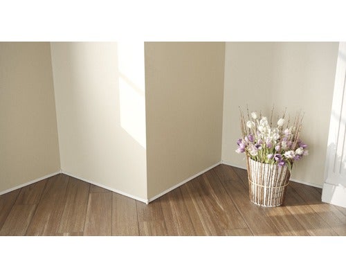 Eckansicht eines Raumes mit weißen Sockelleisten und einem Blumenarrangement