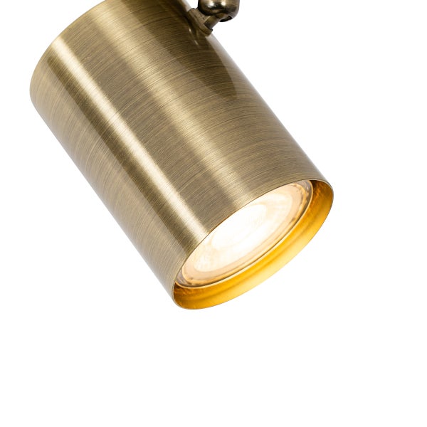 Zylindrischer Strahler aus Metall in Messing-Optik mit warmem Licht.