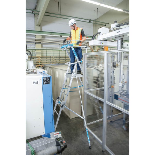 Eine Person steht auf einer Zarges Treppe in einer Industrieumgebung.