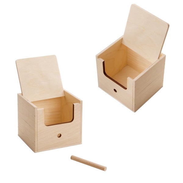 Hölzerner Nistkasten mit geöffnetem Deckel, im Hintergrund ein Nest mit Eiern