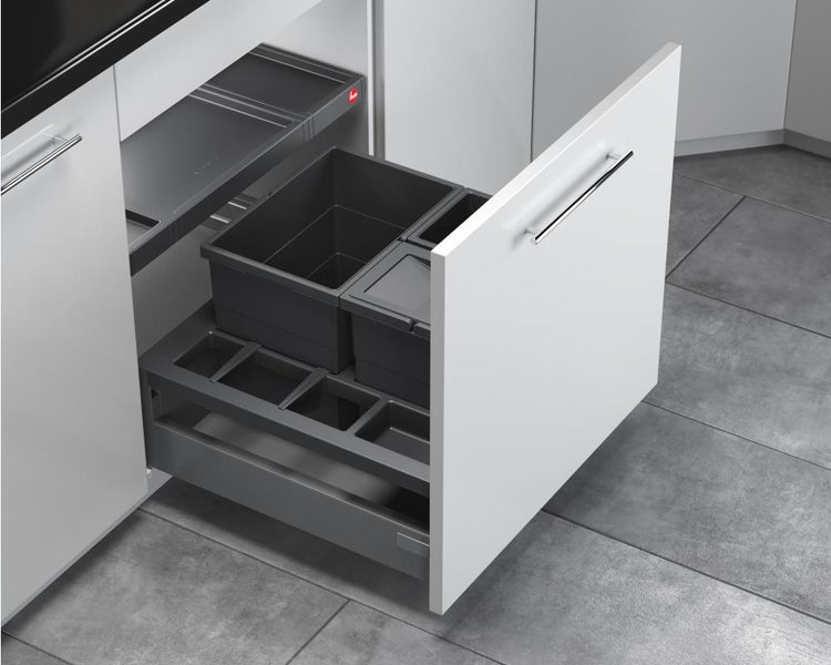 Abfalltrennsystem in einem weißen Küchenauszug mit mehreren grauen Kunststoffbehältern und einer Ablagefläche.