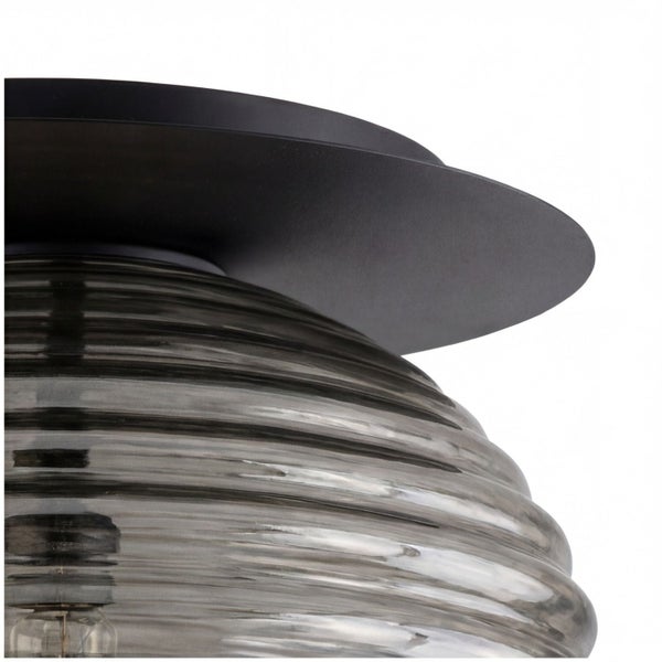 Deckenleuchte mit geriffeltem Schirm aus Rauchglas und schwarzer Metallbasis.