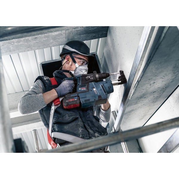 Handwerker bohrt mit einem Akku Bohrhammer in die Decke.