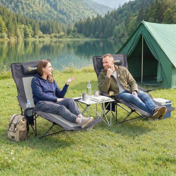 Zwei Personen entspannen in Outsunny Campingstühlen mit Liegefunktion vor einem Zelt an einem See mit Bergblick.