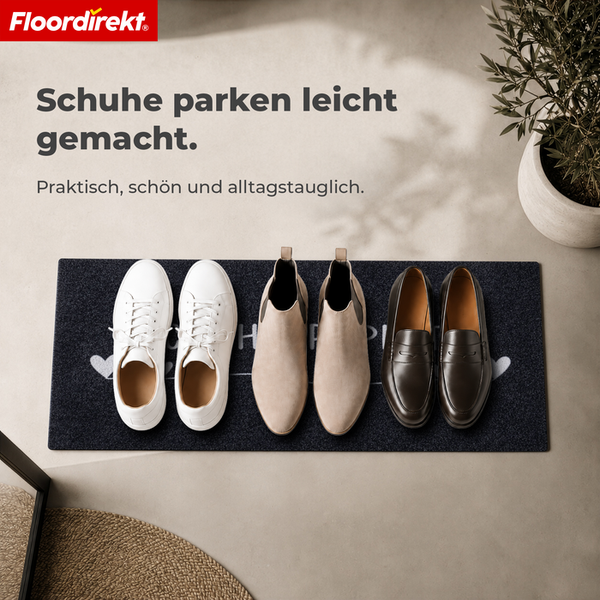 Fußmatte für den Eingangsbereich mit Schuhen und Floordirekt Logo in einer organisierten Wohnumgebung mit Pflanze.