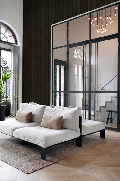 Helles Wohnzimmer mit Sofa, Teppich und Fenstern