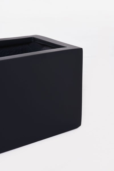 Detailansicht der Ecke eines rechteckigen, schwarzen Pflanzkastens mit matter Oberfläche.