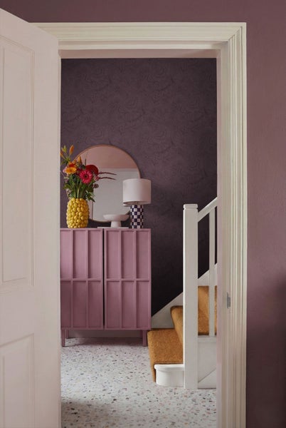 Flur mit Kommode, Spiegel, Lampe, Blumen, Treppe und Musterboden