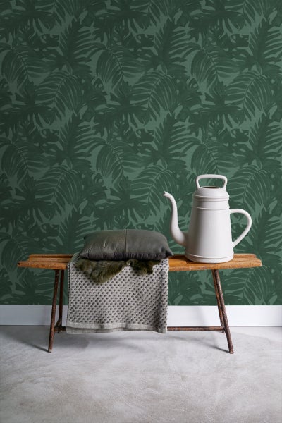 Dekorative Szene mit Blättertapete, Bank, Kissen und Gießkanne