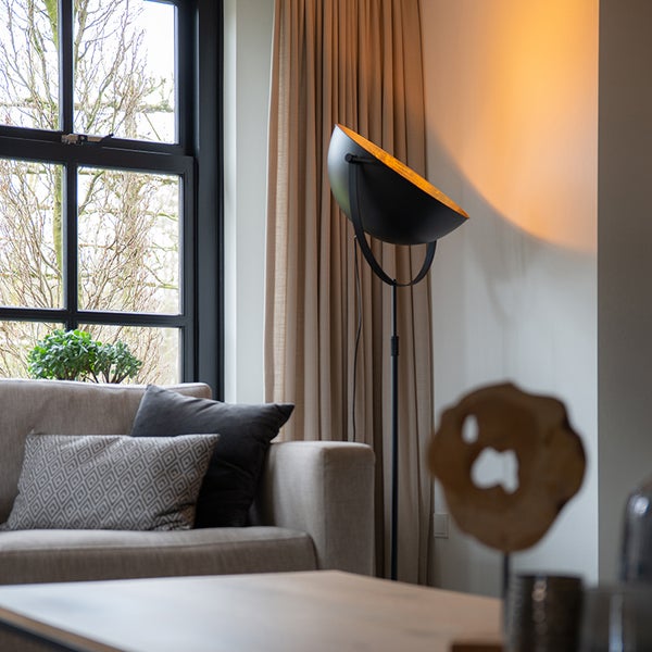 Wohnzimmer mit Sofa, Fenster und Stehlampe im Innenbereich