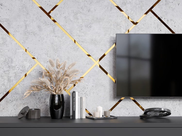 Dekoratives Wohnzimmer mit Fernseher, Betonwand und goldenen Akzenten