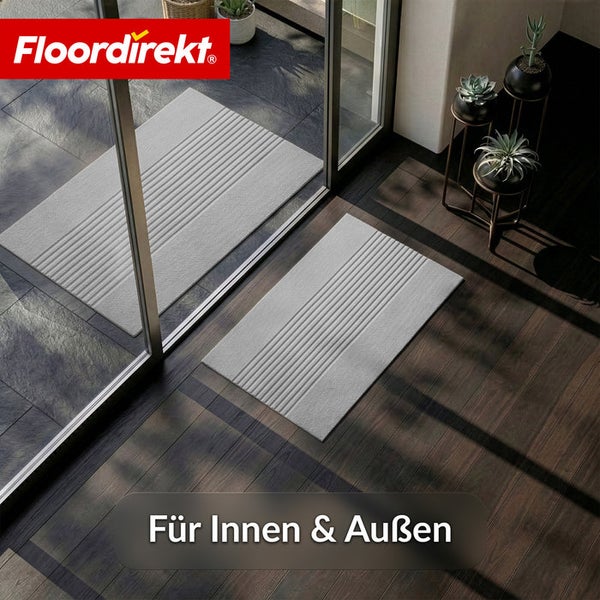 Floordirekt Logo. Zwei hellgraue Fußmatten mit Rillenstruktur vor einer Glastür auf Holz- und Steinboden. Für innen und außen geeignet.
