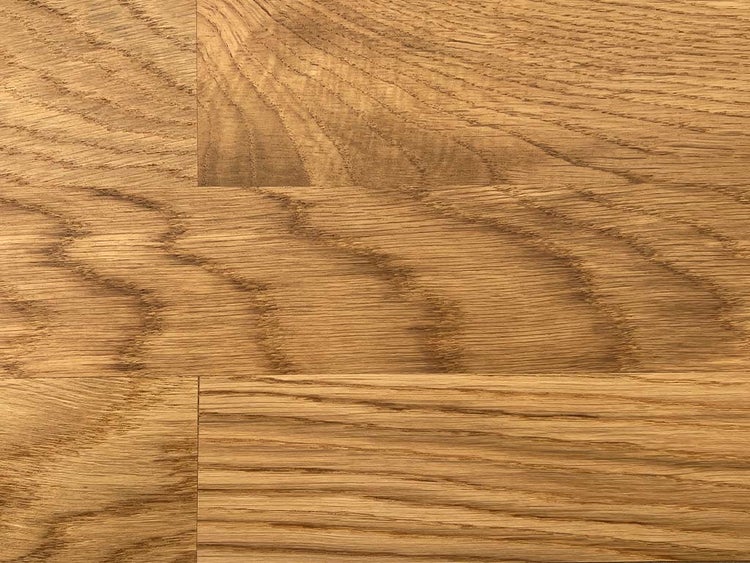 Nahaufnahme von Eichenparkett mit deutlicher, natürlicher Holzmaserung und versetzten Dielen.