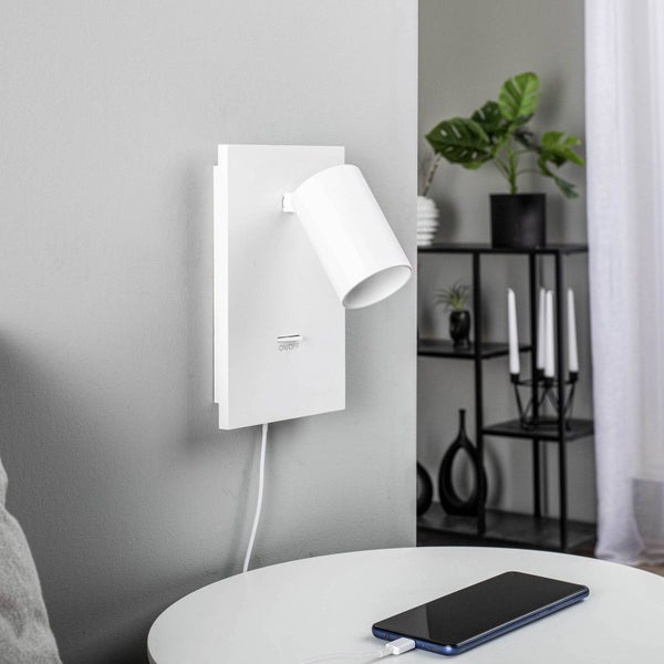 Wandleuchte mit Schalter und USB-Ladeanschluss in einem modernen Wohnzimmer.