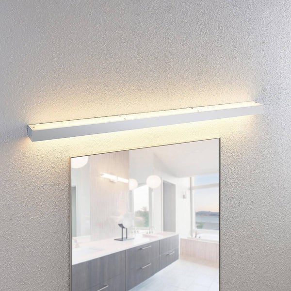 Weiße LED-Spiegelleuchte in schlichtem Balkendesign über einem Badezimmerspiegel, warmweißes Licht strahlt nach oben und unten an die Wand.