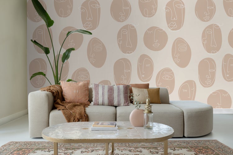 Wohnzimmer mit Sofa, Kissen, Tisch und Wandtapete mit Gesichtsmuster