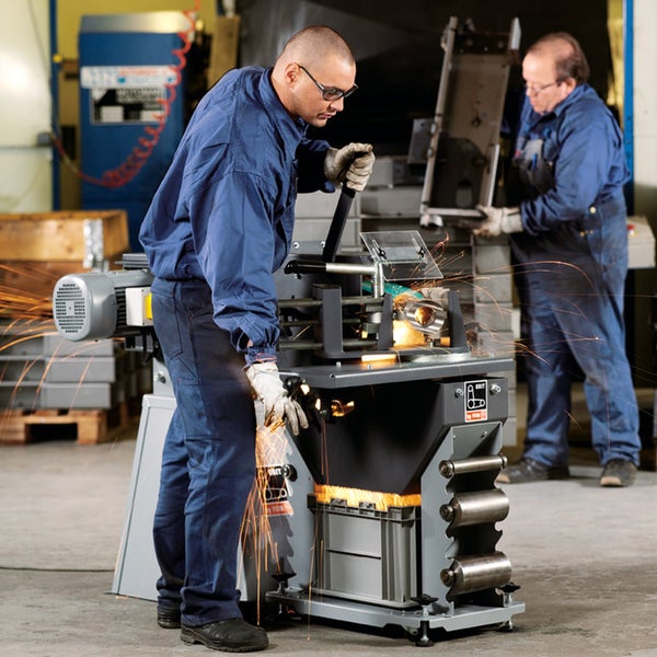 Handwerker bei der Metallbearbeitung mit einer GRIT by FEIN Rohrschleifmaschine in einer Werkstatt, Funkenflug beim Schleifen eines Metallrohrs.