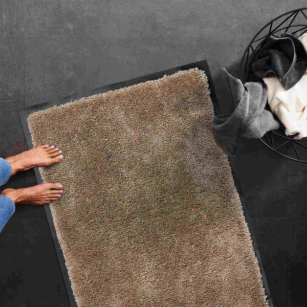 Hochflor Badteppich auf Fliesenboden mit Füßen und Wäschekorb