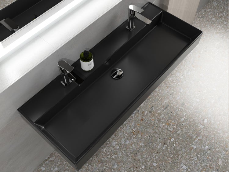 Schwarzes Waschbecken mit zwei Armaturen und Ablaufventil im Badezimmer