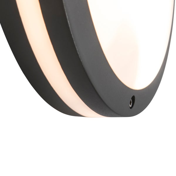 Nahaufnahme einer runden Wandleuchte in Schwarz mit einem weißen Lichtdiffusor.